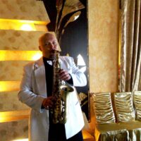 Saxophonist RusAlex im weißen Anzug bei einer Feier